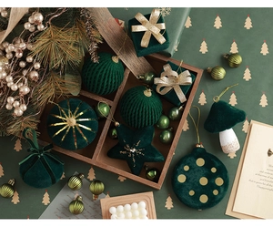Detail of dark green velvet Christmas ornaments in star and mushroom shapes with gold trim