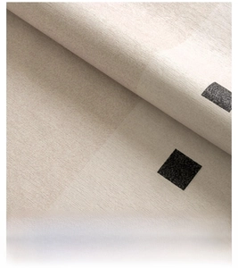 Close-up of beige chenille rug with black squares showing soft texture and tight weave