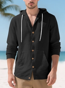 Detail of black hooded linen shirt with wooden buttons and textured fabric on beach