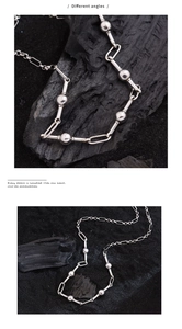 Detail showing various angles of a silver-toned mixed chain necklace with sphere beads