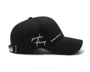 Detail view of cotton baseball cap with white cursive letter embroidery and metal buckle