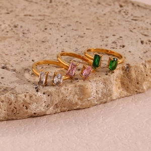 Detailed shot of gold open rings with rectangular and oval crystals in three colors