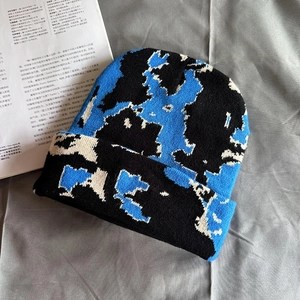Macro detail of blue and black knitted beanie showing soft pixelated texture on fabric