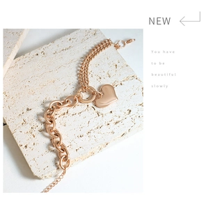 Detail of rose gold heart charm bracelet with combined curb and double link chain