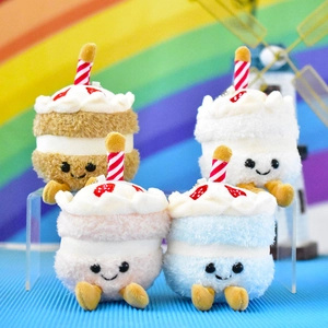 Detailed view of four colorful mini cake plush pendants with cute smiling faces.