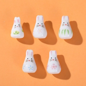 Five ceramic bunny charms with floral patterns like cherry blossoms and plum blossoms