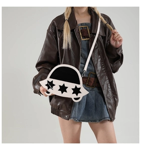 Détail du sac bandoulière en forme d'OVNI avec motif étoiles porté par un mannequin