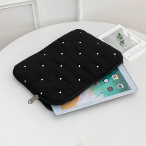 Detailed view of black polka dot quilted laptop sleeve with metallic zipper closure