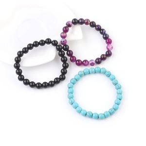 Detailed shot of 8mm beaded bracelets in polished black, striped purple, and textured blue