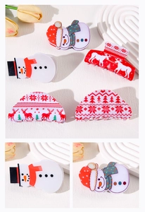 Detailed close-up of acrylic Christmas hair claws with festive snowman and reindeer patterns