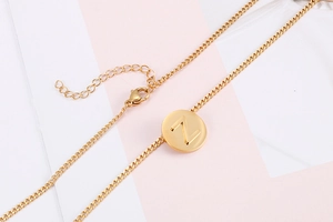 Macro view of gold letter Z round pendant necklace with lobster clasp and chain details