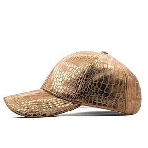 Metallic gold baseball cap with embossed crocodile texture and curved brim in side view