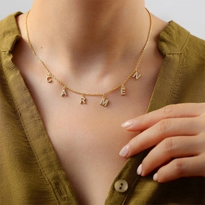 Vue détaillée d'un collier en acier doré avec des charms en zircons CZ étincelants.