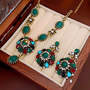 Close-up of vintage gold floral necklace and earring set with colorful gemstones