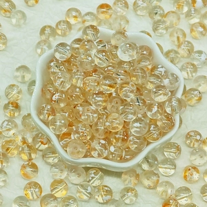 Macro shot of clear glass beads with orange floral inclusions for DIY jewelry