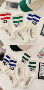 Detail of white cotton athletic crew socks with red, green and blue stripes and numeric logo