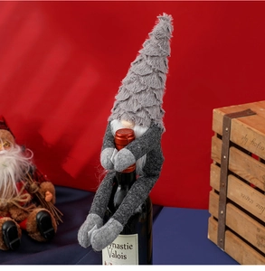 Detail of grey plush Christmas gnome wine bottle cover with long white beard decoration