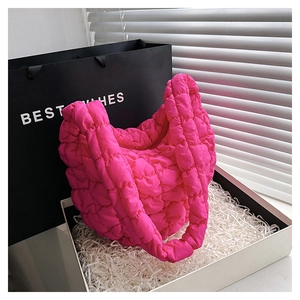 Detail view of quilted bubble cloud bag in bright pink with soft texture in gift box