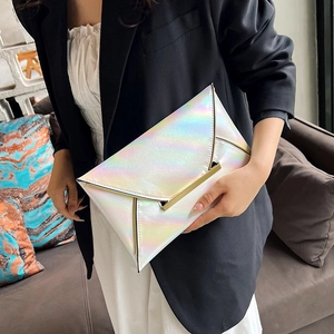 Detail of holographic envelope clutch bag with gold metal trim held by a model