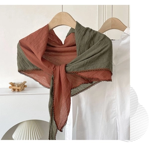 Detail of color-block linen scarf in rust red and olive green with crochet trim edges