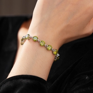 Detail of elegant silver tennis bracelet featuring round-cut faceted green zircons