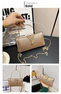 Detailed view of gold glitter evening bag with leaf-shaped metal clasp and ring handle