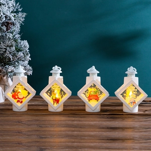 Set of four white Christmas lanterns with warm LED lights on a dark wooden surface