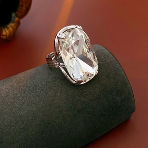 Close-up of geometric silver ring featuring a large emerald-cut clear crystal stone