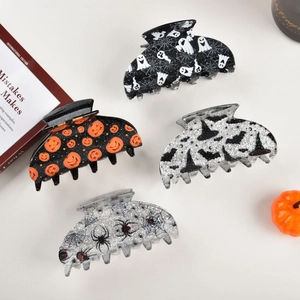 Detail of Halloween hair claws featuring pumpkin and ghost prints with glitter finish