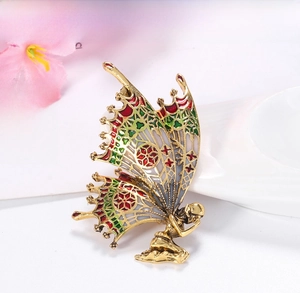 Macro view of vintage butterfly angel brooch with colorful enamel details and gold finish
