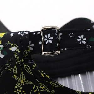 Close-up of metal buckle and floral pattern strap on the black sun hat