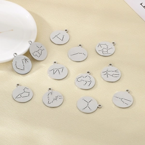 Set of 12 circular silver stainless steel zodiac charms with diamond accents on fabric