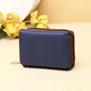 Detail of navy blue tri-fold wallet with brown lining and gold ring zipper head
