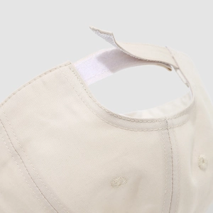 Dettaglio del cappellino in cotone con cinturino regolabile in velcro sul retro
