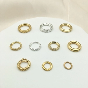 Anelli assortiti in oro e argento sabbiato con motivi a trama e drago per gioielleria