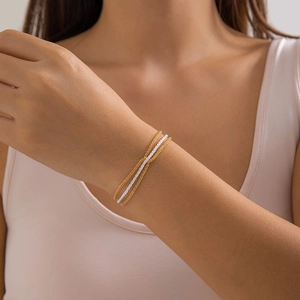 Detail view of minimalist three-piece chain bracelet set in gold and silver finish