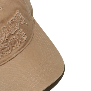 Dettaglio del cappellino in cotone kaki con ricamo vintage e finiture sfilacciate