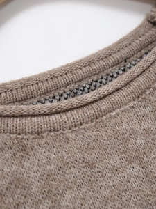 Close-up of ribbed crew neck on taupe knit sweater showing detailed wool texture