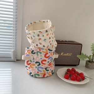 Quilted fabric storage baskets with cute bear and floral patterns in a sunny home setting