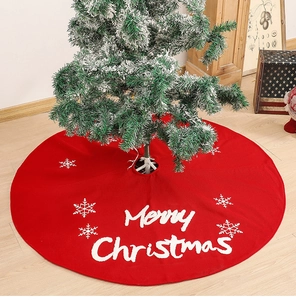 Detail of red knitted Christmas tree skirt featuring white Merry Christmas embroidery