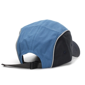Detail view of a 5-panel camper cap with blue and black contrast panels and adjustable strap
