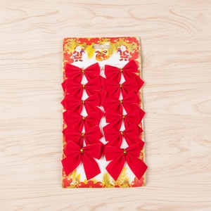 Set of 12 festive red velvet Christmas tree bows on a decorative holiday display card