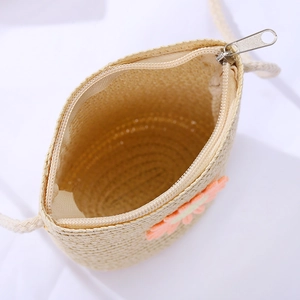 Detail of woven straw crossbody bag with orange flower applique and secure zipper closure