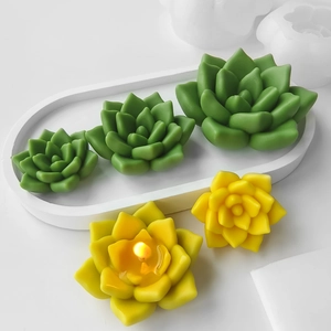 Detailed view of colorful succulent candles crafted from silicone molds on a white tray