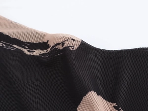 Détail du tissu en maille respirante noir et chair avec motifs abstraits d'encre