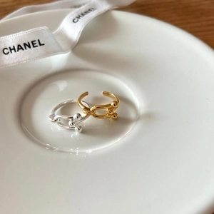 Close-up of minimalist S925 silver and gold U-link open rings on a ceramic tray