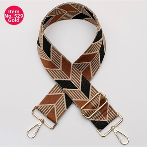 Detail of adjustable woven bag strap with geometric patterns and gold lobster clasps