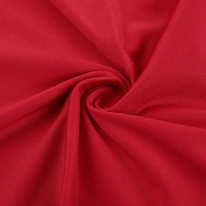 Macro du tissu en maille rouge avec plis en spirale et éclat soyeux délicat