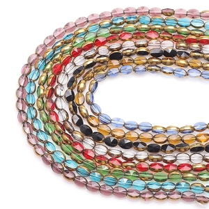 Close-up of multicolored 6x8mm faceted glass beads arranged in a U-shape on white background