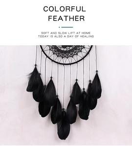 Detail showing delicate lace weaving and hanging black feathers with beads on dreamcatcher